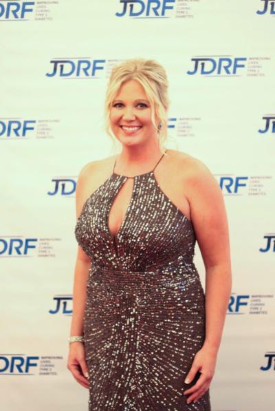 Diana stands against a JDRF background